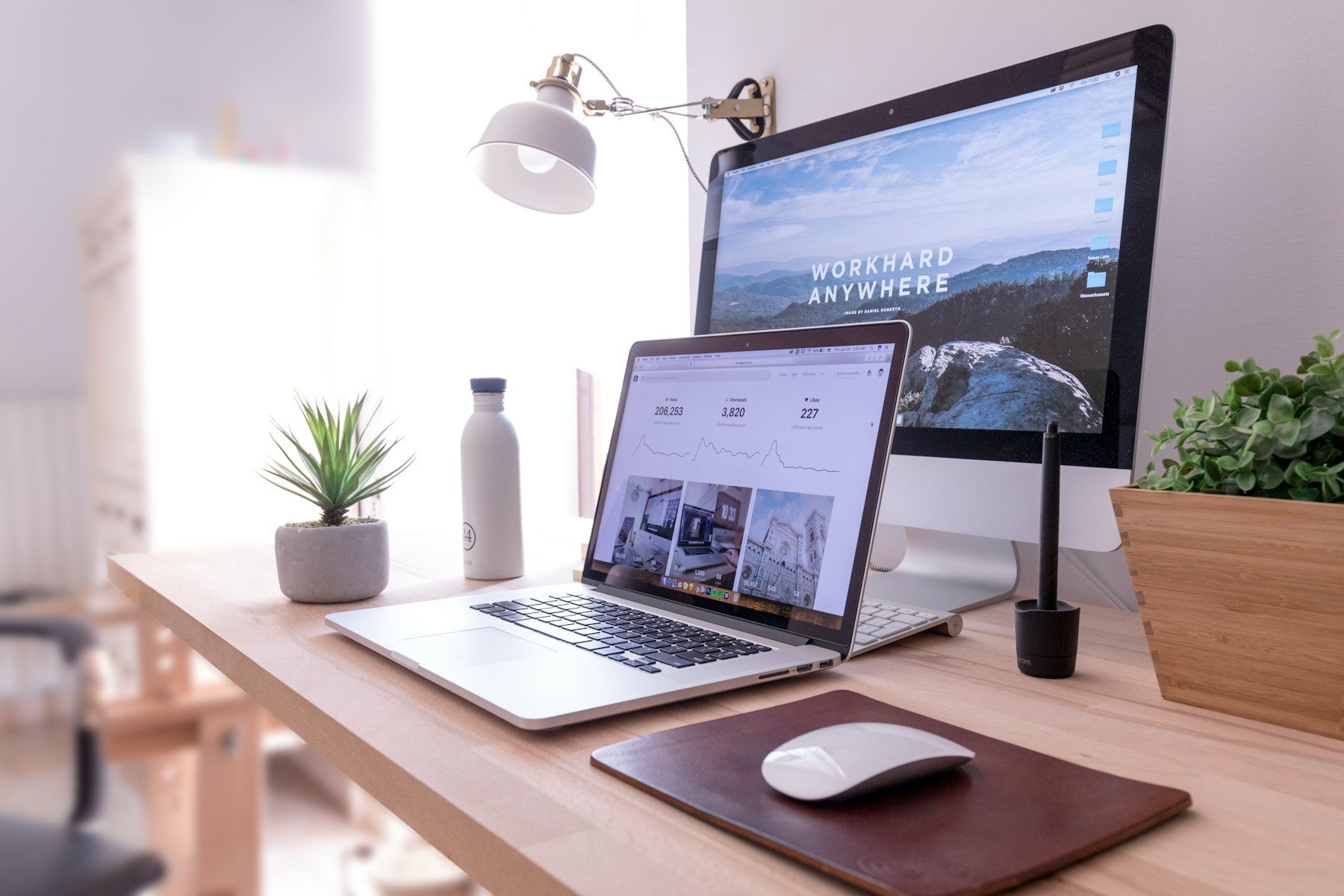 A bright desk with a laptop and monitor