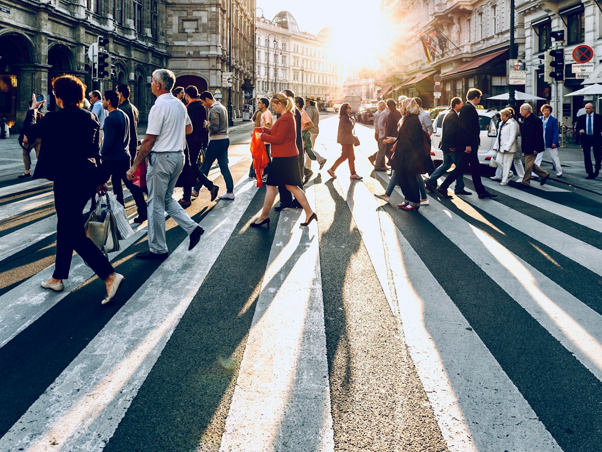 People crossing a sunlit city street